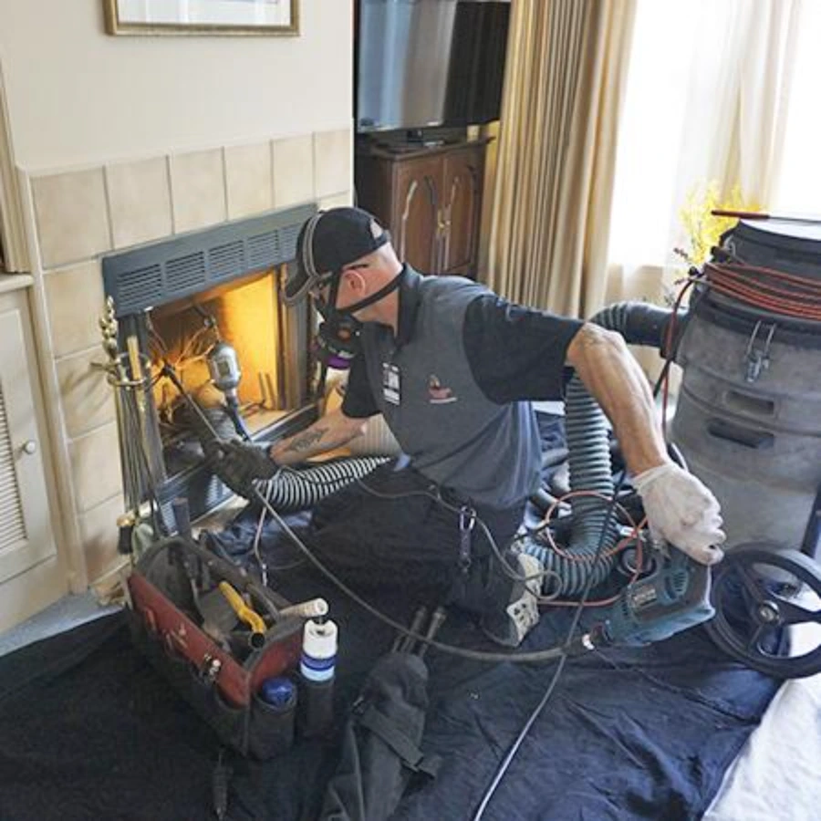 Chimney sweep technician setting up interior dust containment before a sweep in Dallas, TX
