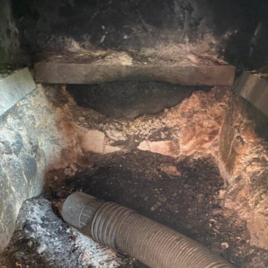 Firebox and flue with heavy creosote and soot buildup before a chimney sweep