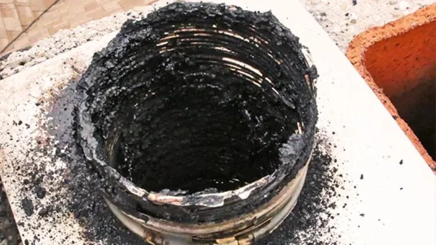 Wood stove flue with heavy creosote glazing before a professional sweep